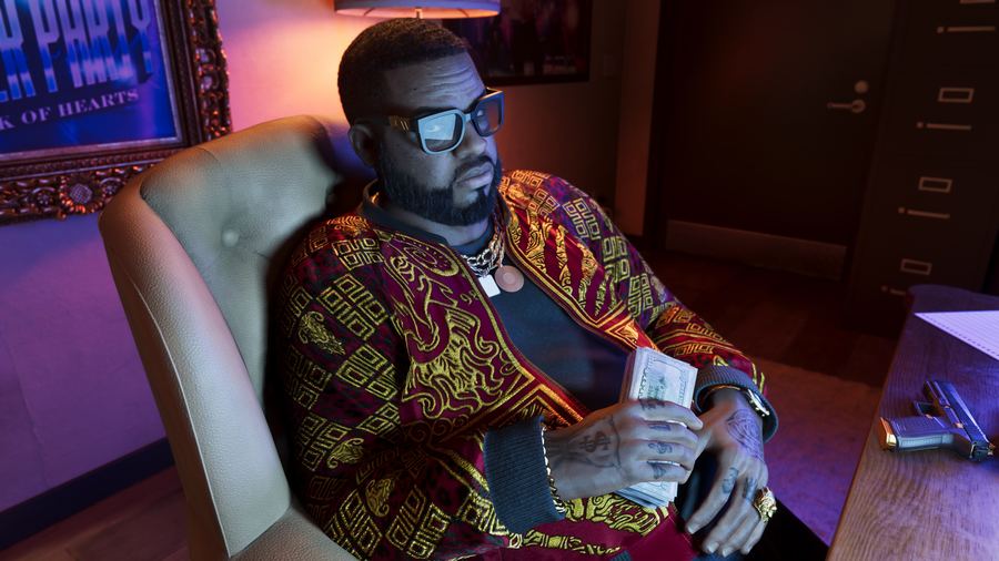 Boobie Ike sitting at a desk in a patterned shirt