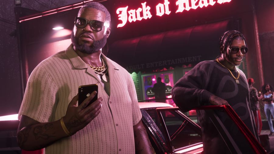 Boobie Ike checking his phone outside the Jack of Hearts club at night