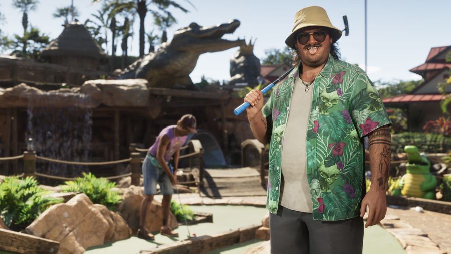 Cal Hampton in a patterned shirt standing near a large alligator statue