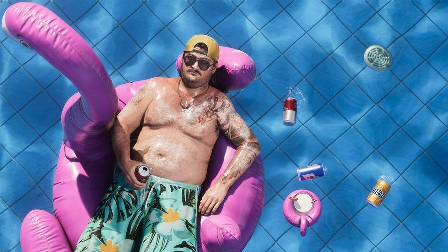 Cal Hampton floating on a flamingo pool inflatable surrounded by cans