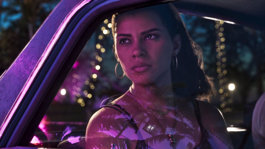 Lucia Caminos in the driver's seat of a car lit by pink neon at night