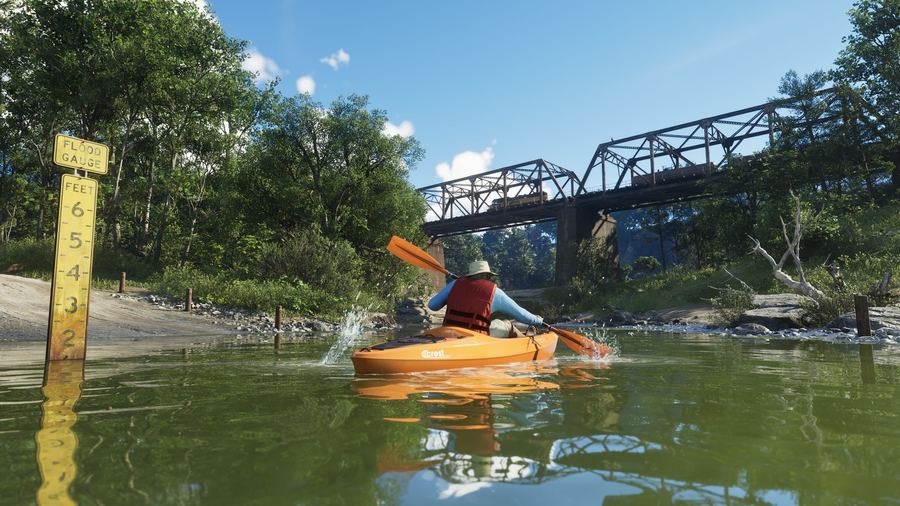 A person kayaking on a calm river beneath a steel bridge