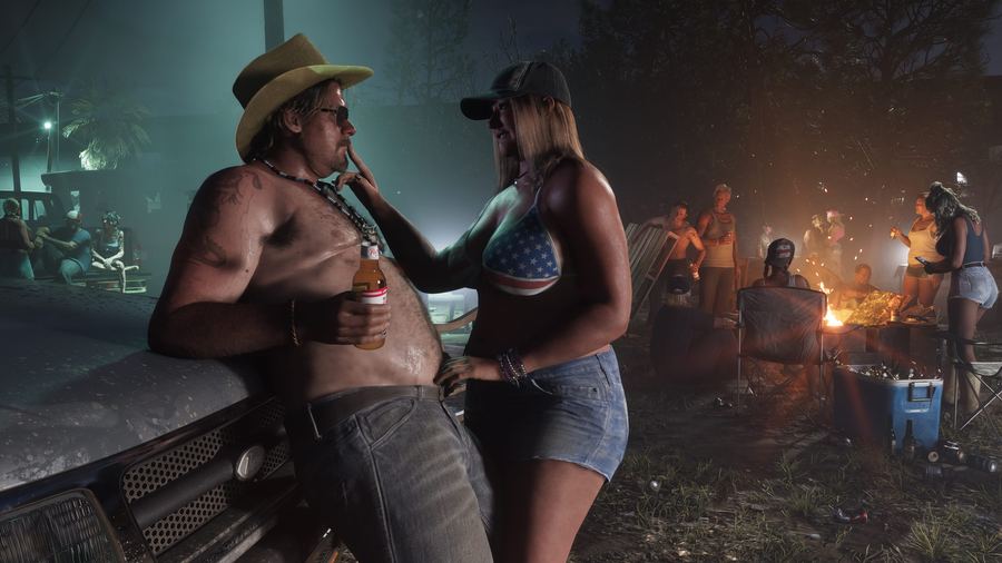 People drinking around a fire at an outdoor gathering at dusk