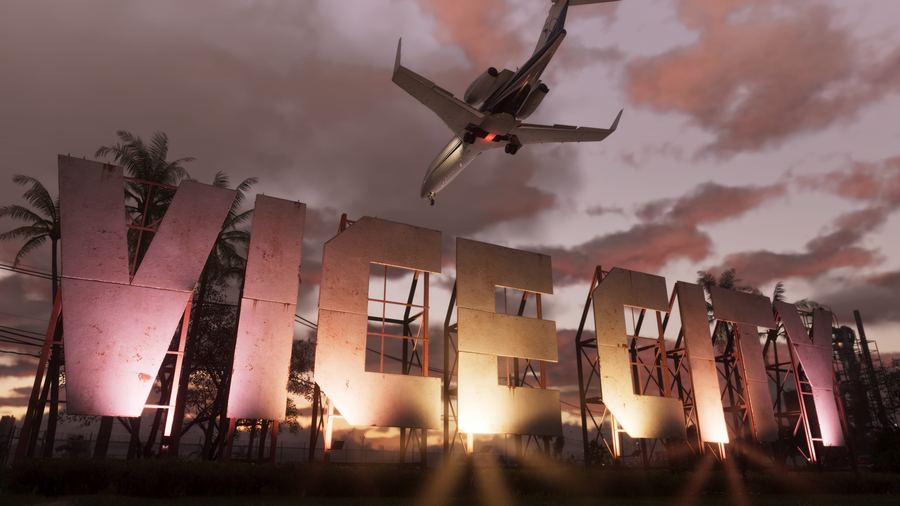 A large VICE CITY sign silhouetted against an orange sunset with a plane overhead
