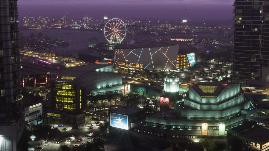 A night-time aerial view of a lit Vice City fairground and waterfront
